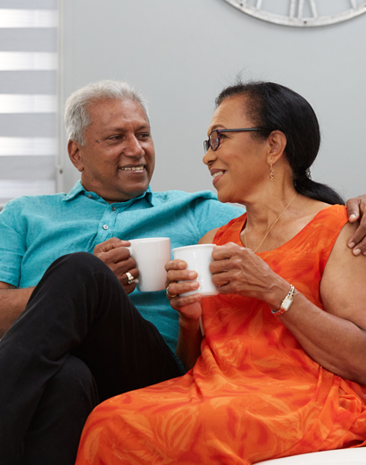 Mature couple enjoy coffee on their couch with a First Citizens Equity Mortage