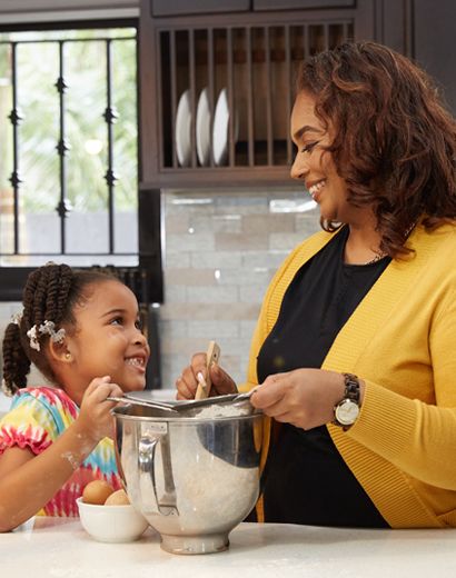 Mother and daughter enjoying a moment in their kitchen with a First Citizens Acquisition Mortgage