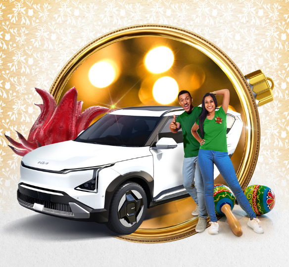 Young couple posing next to the KIA electric SUV More the Merrier grand prize.