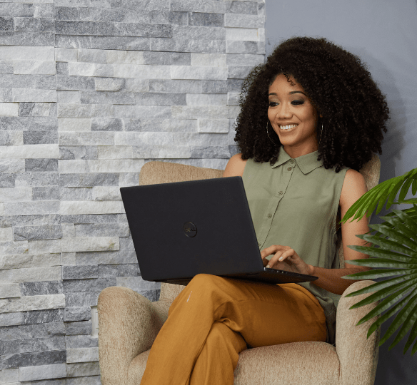 Young lady sitting with laptop on top of her
