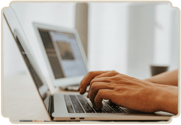 Image of a hand typing on a laptop