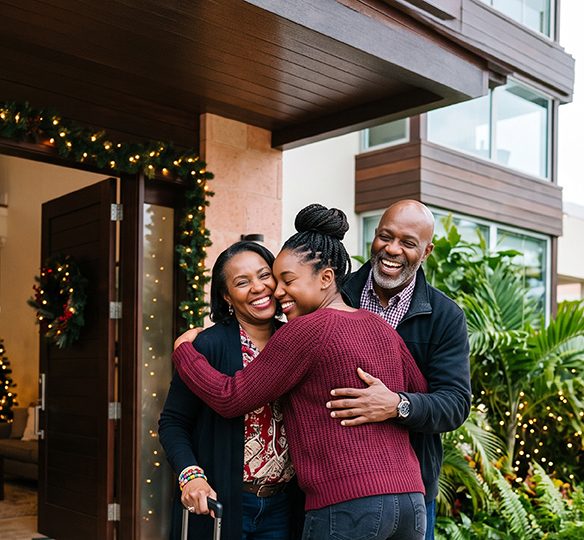 More the Merrier Mortgage image with young lady hugging her parents in front their home